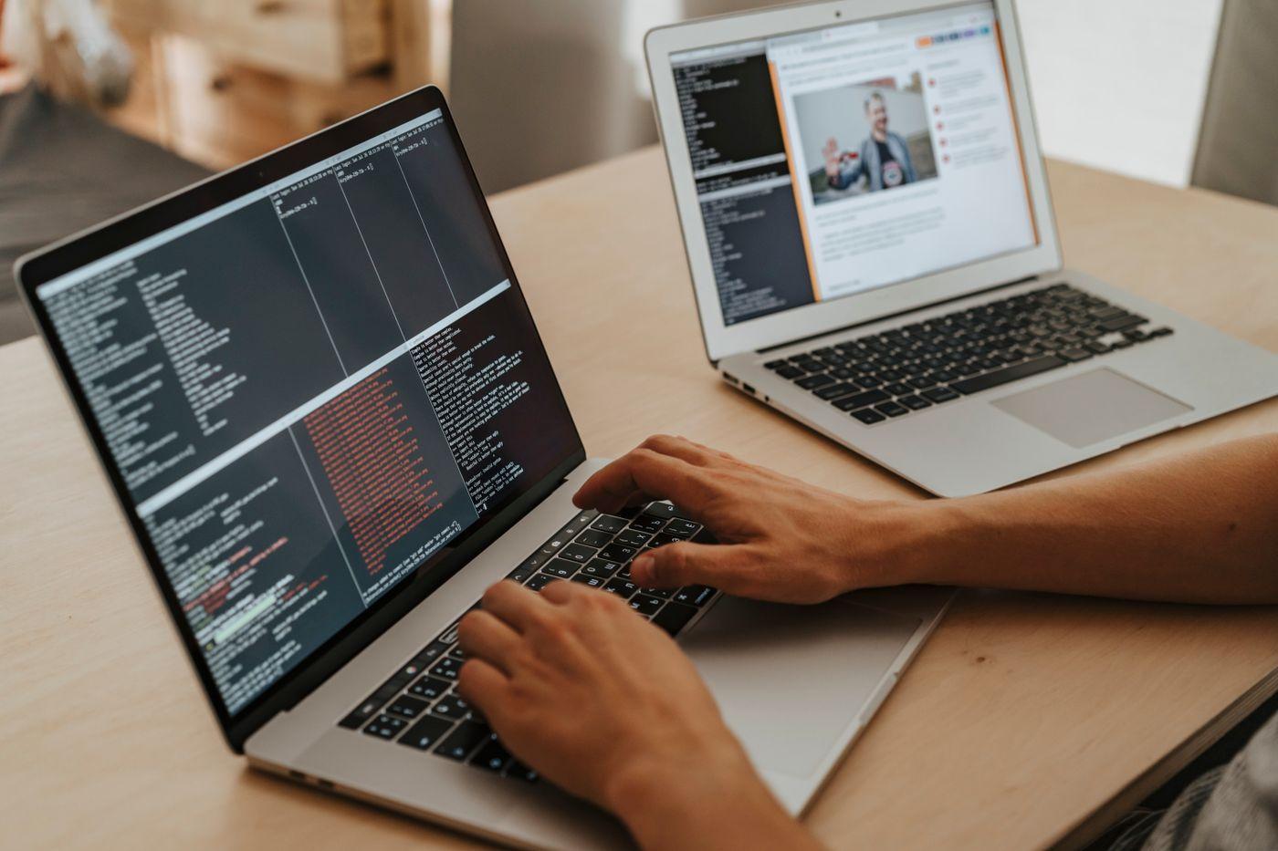 Developer remediating website code on a laptop, with a live web page open on a second screen