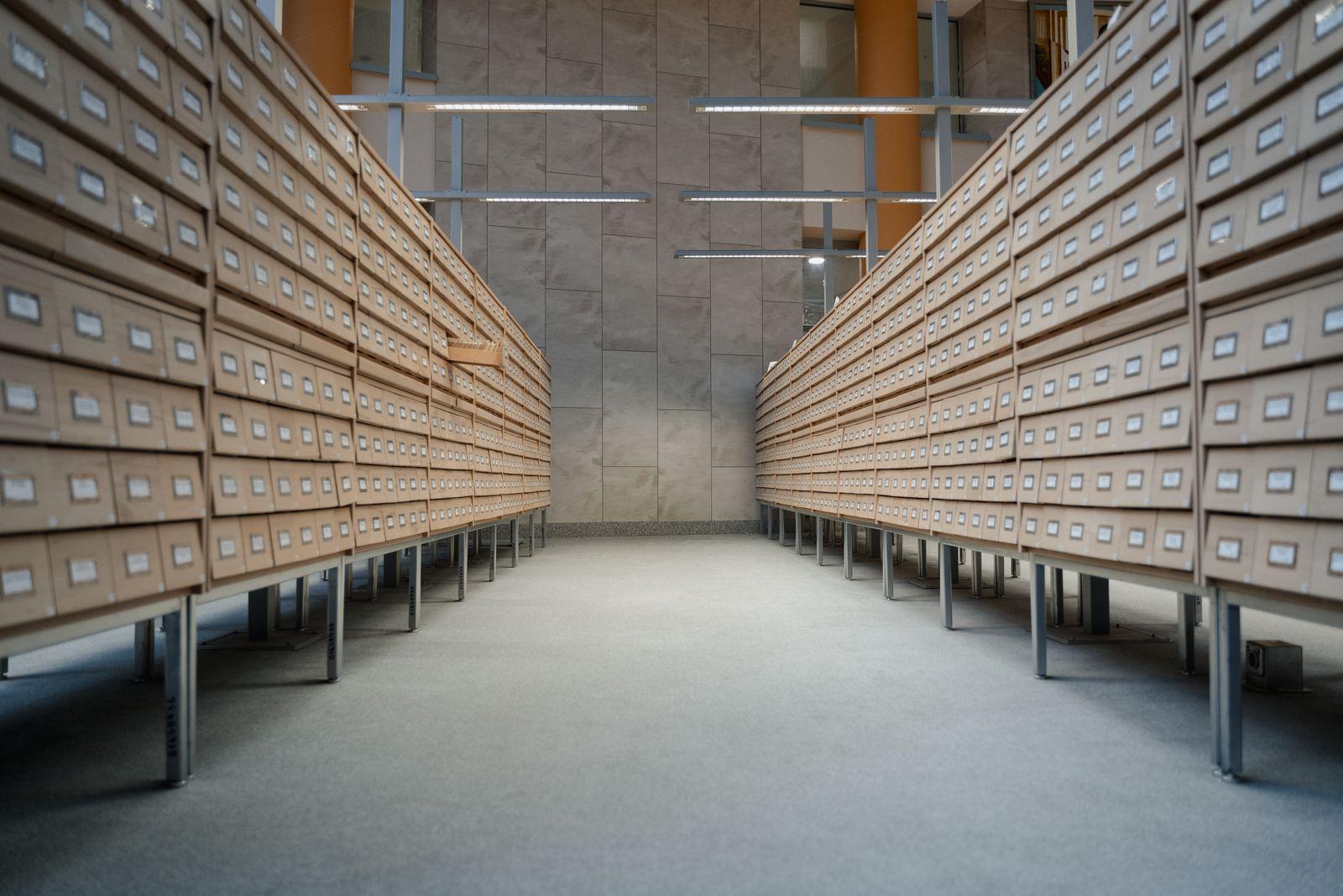 Rows of labelled wooden index drawers in a document records archive