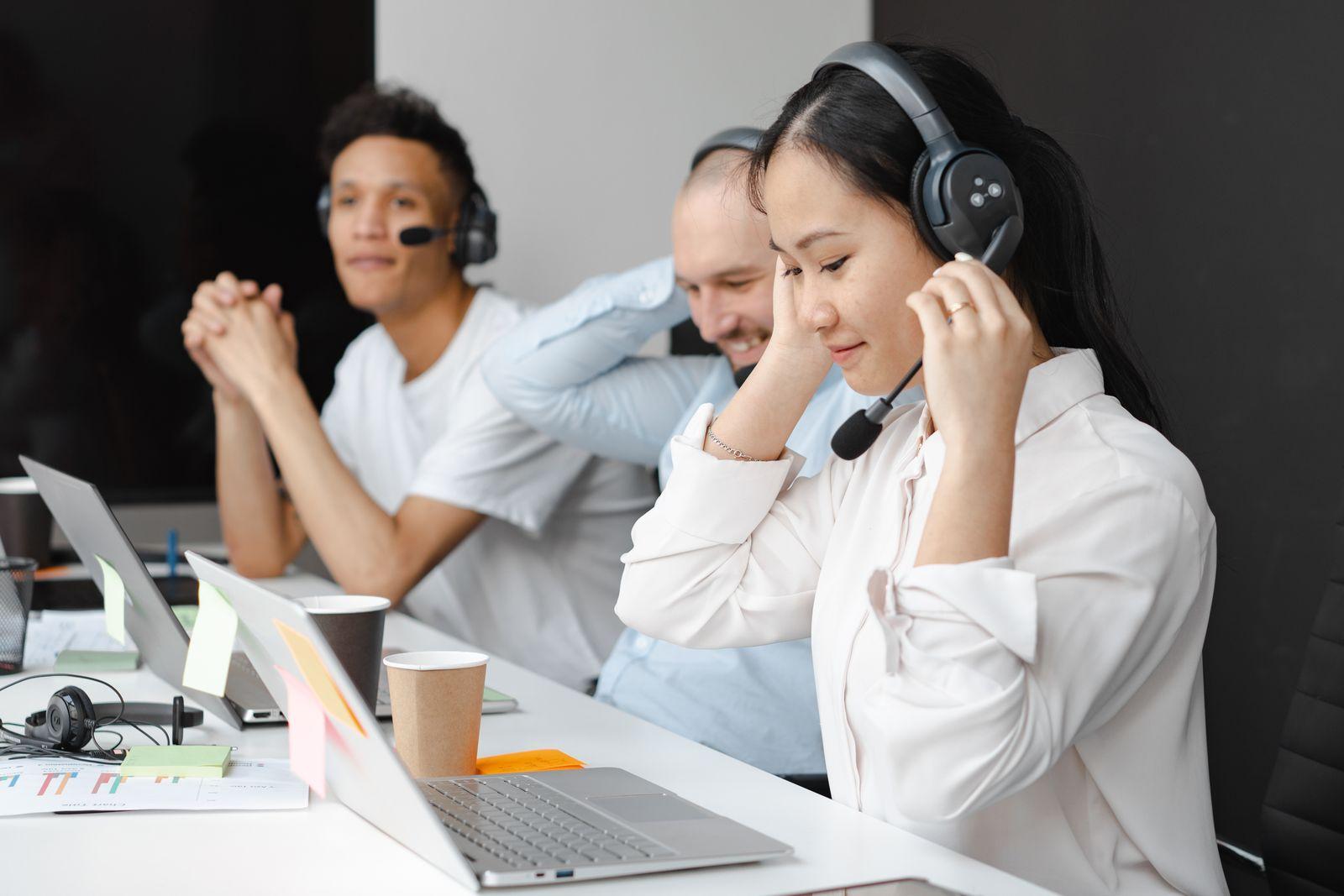 Team of professional interpreters with headsets and laptops handling live sessions