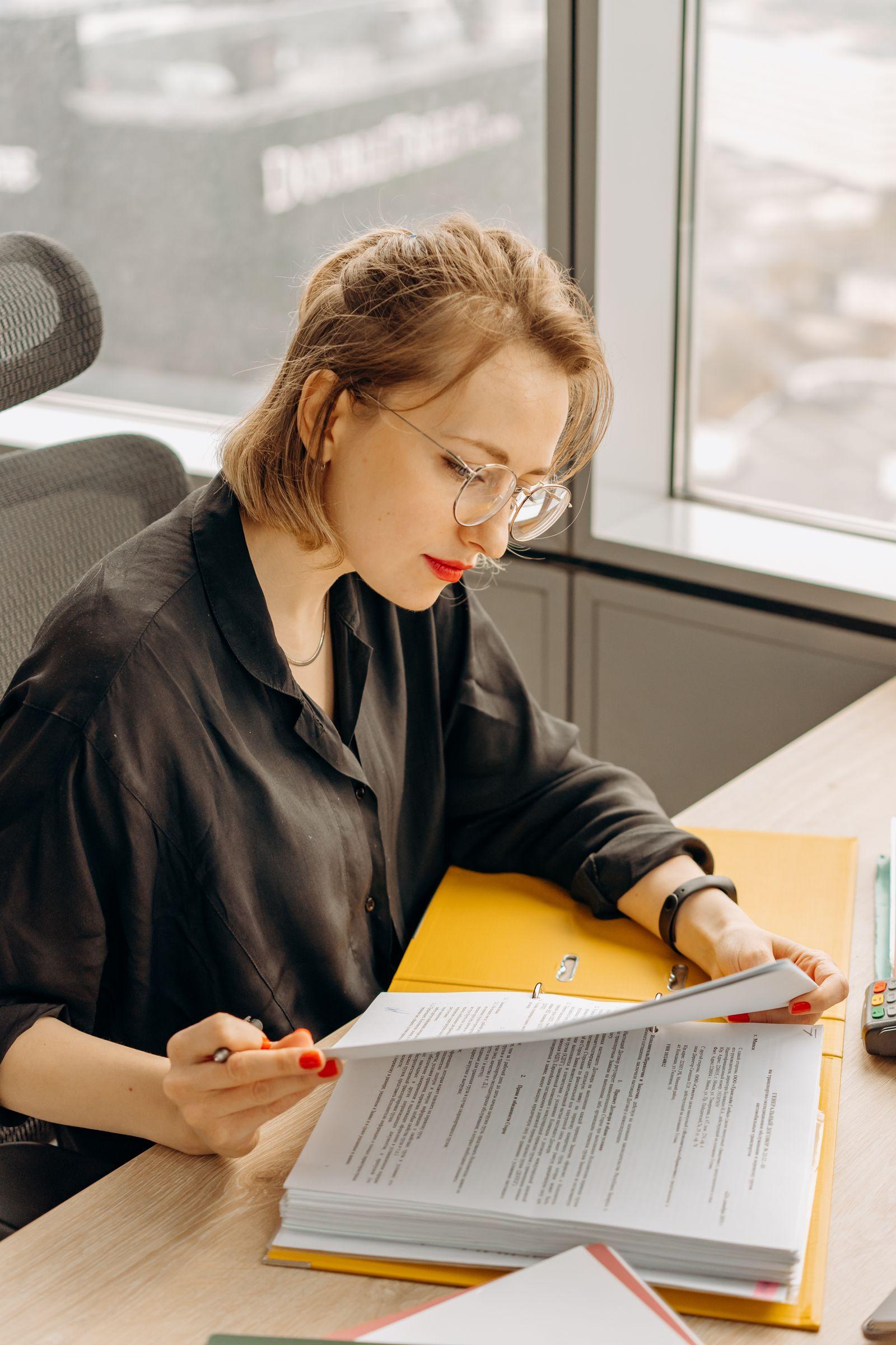 Professional linguist carefully reviewing a translated document at her desk